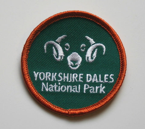 Image shows green round woven badge with Yorkshire Dales National Park rams head logo on.